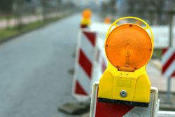 Reflektierende Straßensperre oder Baustellensperre mit Signallampe auf einer Straße. Rote und weiße Straßenbarrikade.